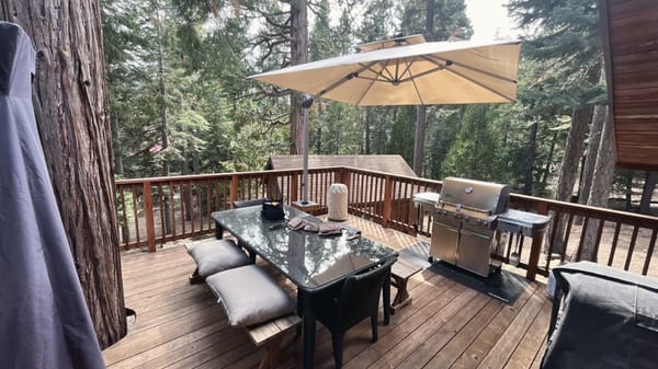 Deck with an umbrella, dining table and grill