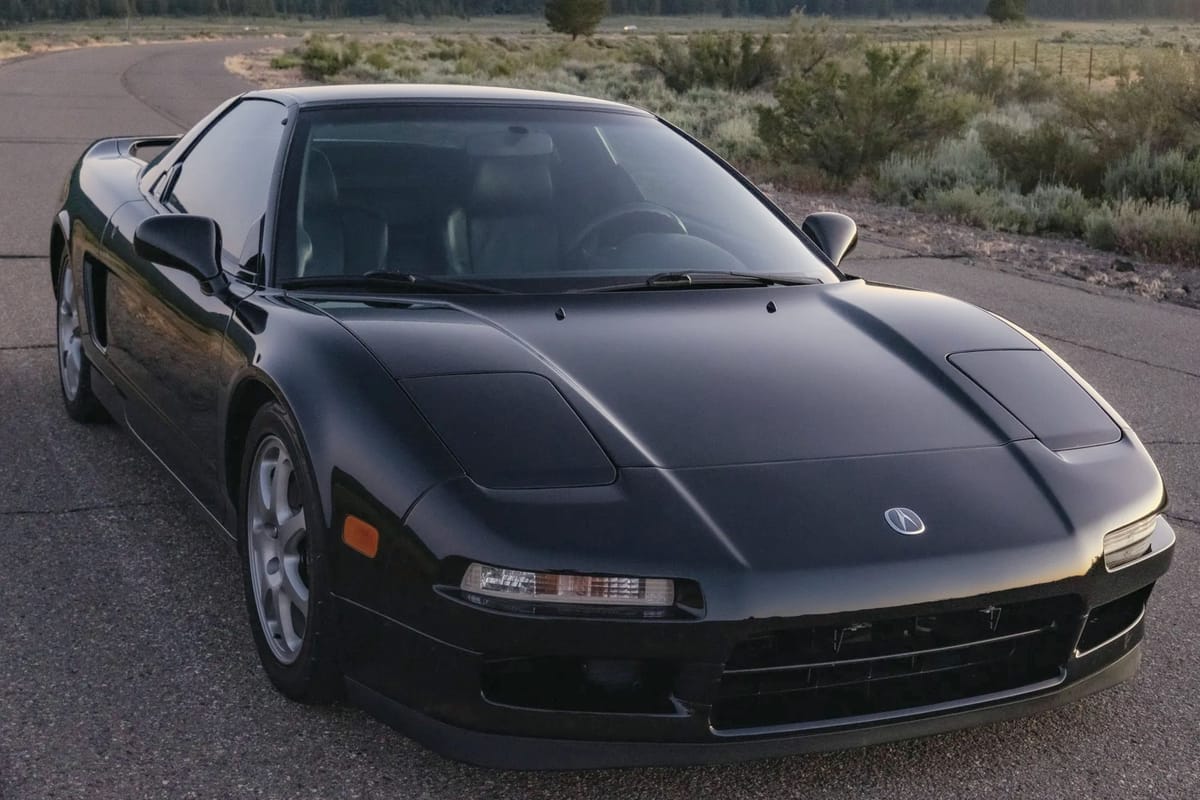 Black sports car on an empty road at dusk